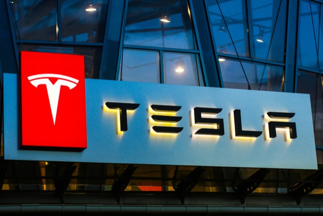 Teslas logga på skylt på husbyggnad där Teslabilar säljs